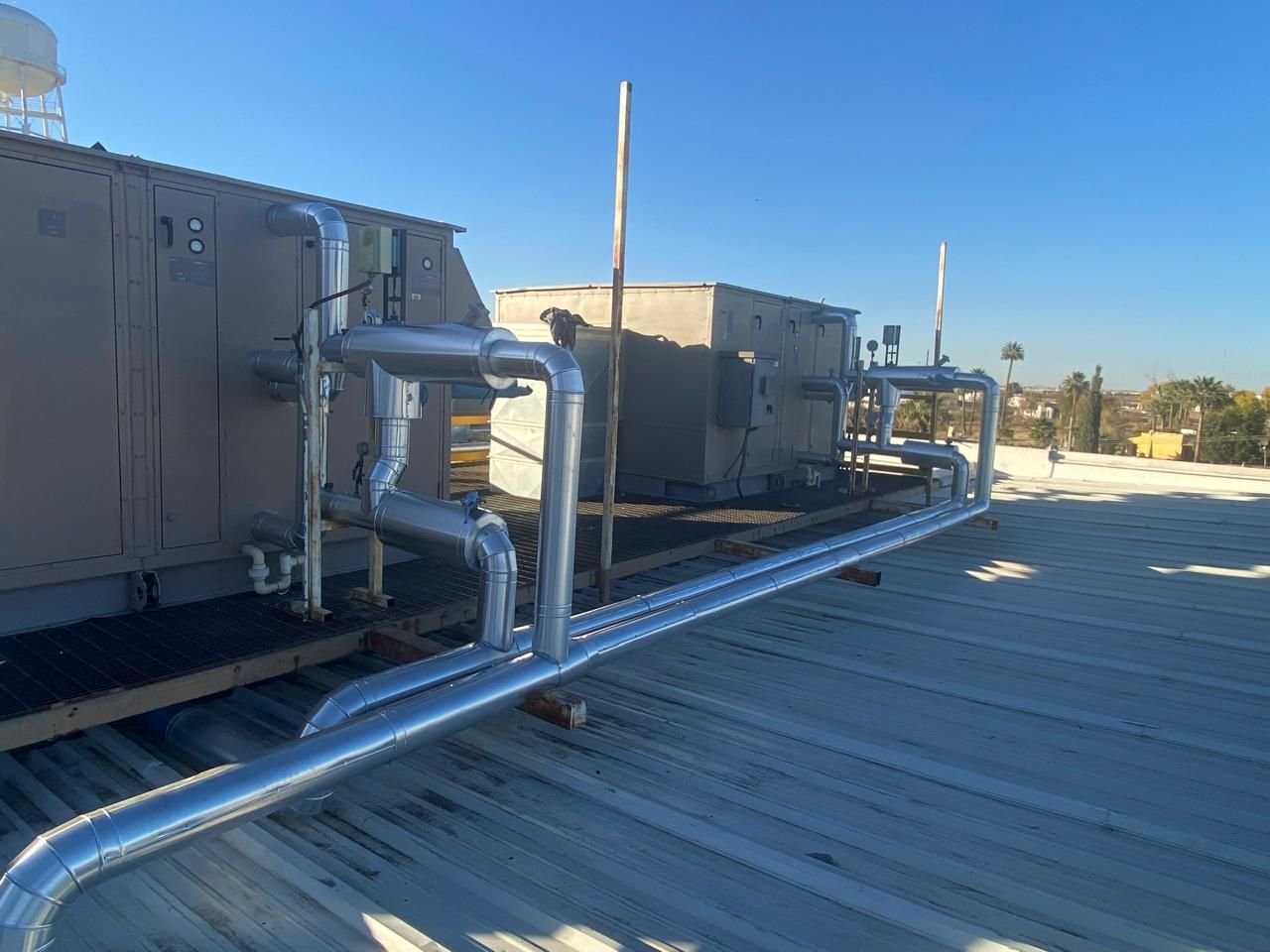 Instalación de tubería y ductos de ventilación industrial en azotea, conectados a equipos HVAC